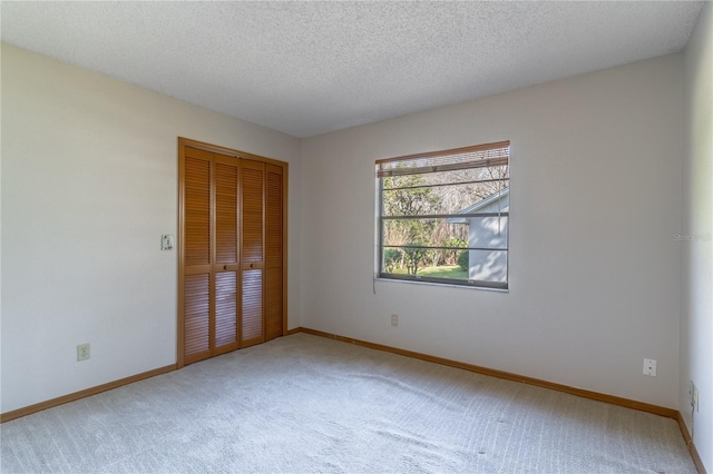 unfurnished bedroom with carpet floors, a closet, and a textured ceiling