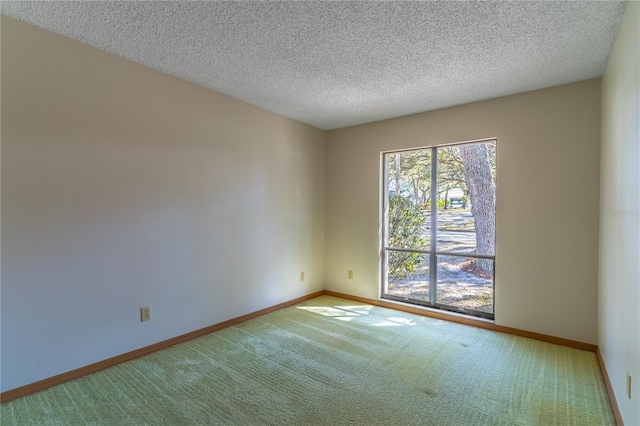 carpeted empty room featuring a textured ceiling