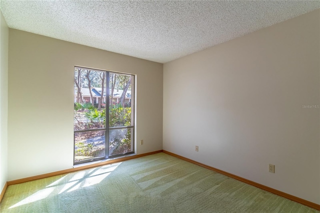 carpeted empty room with a textured ceiling