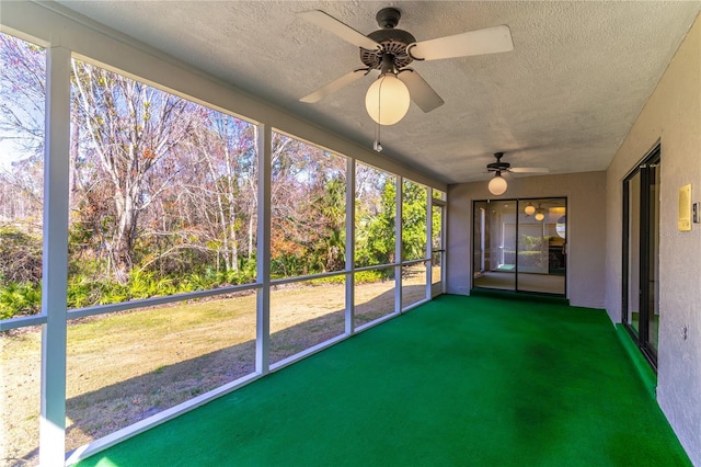 unfurnished sunroom featuring ceiling fan