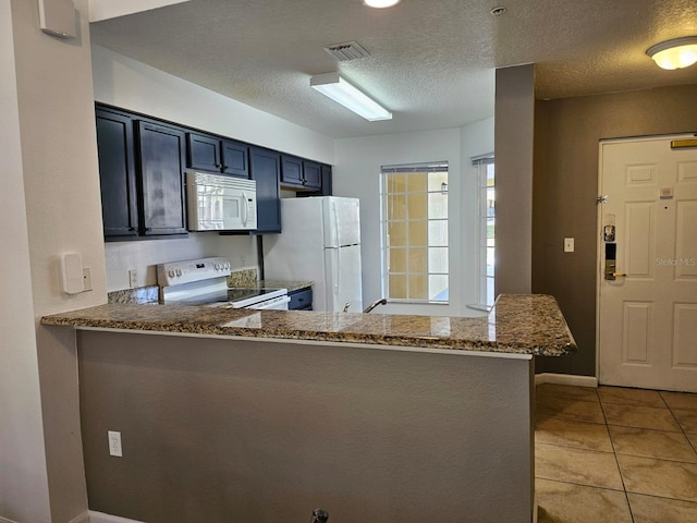 kitchen featuring light tile patterned flooring, a kitchen breakfast bar, kitchen peninsula, white appliances, and light stone countertops