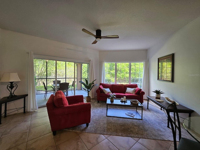 living room featuring ceiling fan, a textured ceiling, and light tile patterned floors