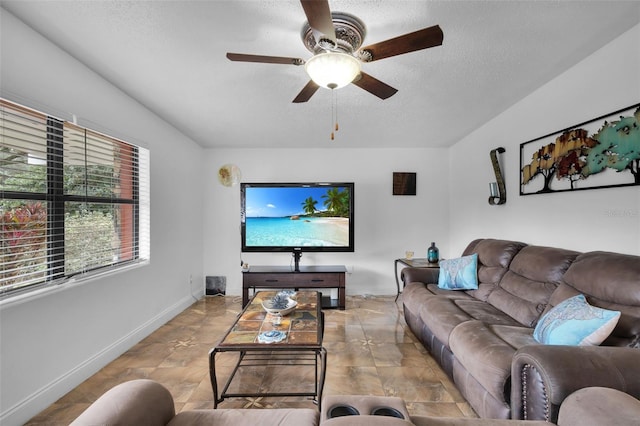 living room with ceiling fan and a textured ceiling