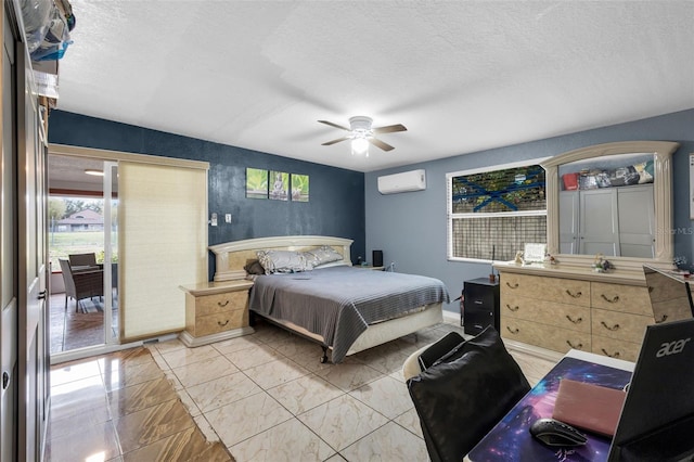 bedroom with ceiling fan, access to outside, a wall unit AC, and a textured ceiling