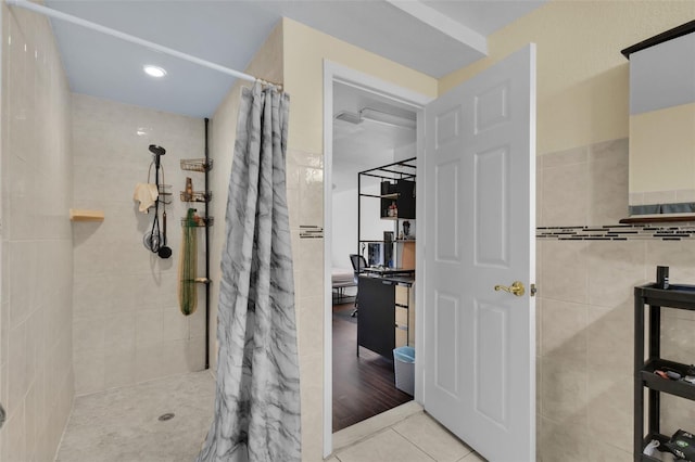 bathroom featuring tile patterned flooring, a shower with shower curtain, and tile walls