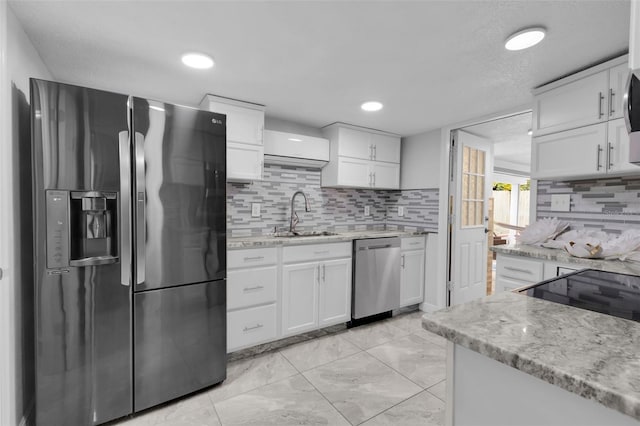 kitchen with sink, light stone counters, tasteful backsplash, stainless steel appliances, and white cabinets