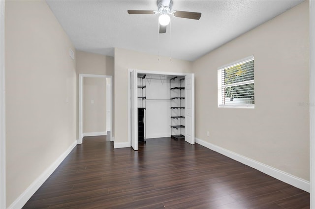 unfurnished bedroom with dark hardwood / wood-style flooring, ceiling fan, a closet, and a textured ceiling