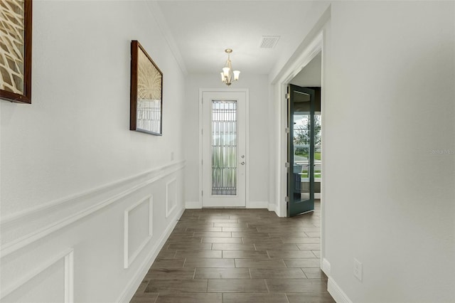 foyer featuring crown molding and a chandelier