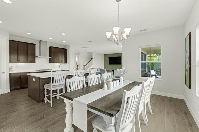 dining area with dark wood-type flooring and an inviting chandelier