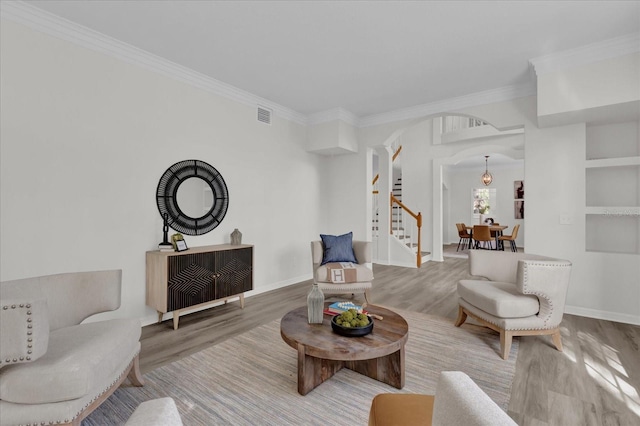 living room with wood-type flooring and ornamental molding