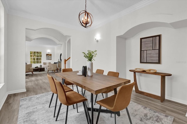 dining room with an inviting chandelier, hardwood / wood-style floors, and ornamental molding