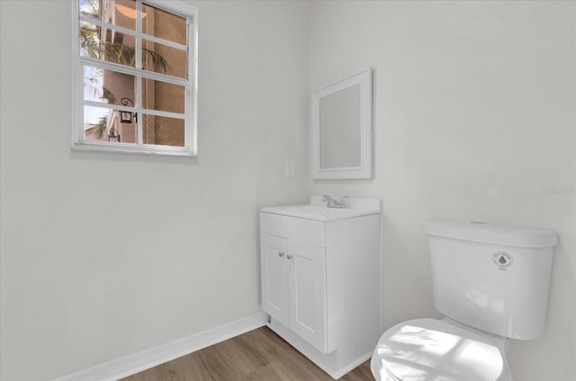 bathroom with vanity, toilet, and hardwood / wood-style floors