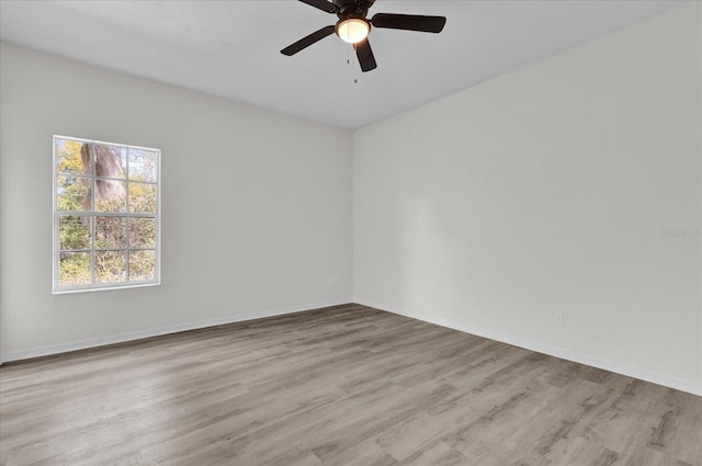 spare room with ceiling fan and light wood-type flooring