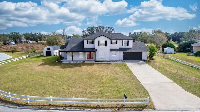 view of front of home with a storage shed, a garage, and a front lawn