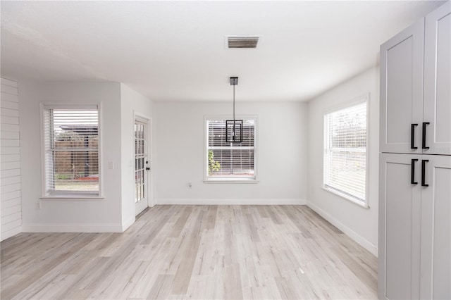 unfurnished dining area featuring a wealth of natural light and light hardwood / wood-style floors