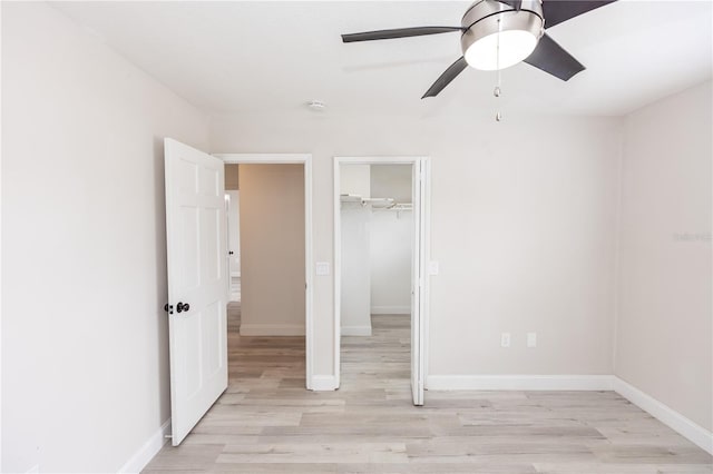 unfurnished bedroom featuring ceiling fan, light hardwood / wood-style floors, and a closet