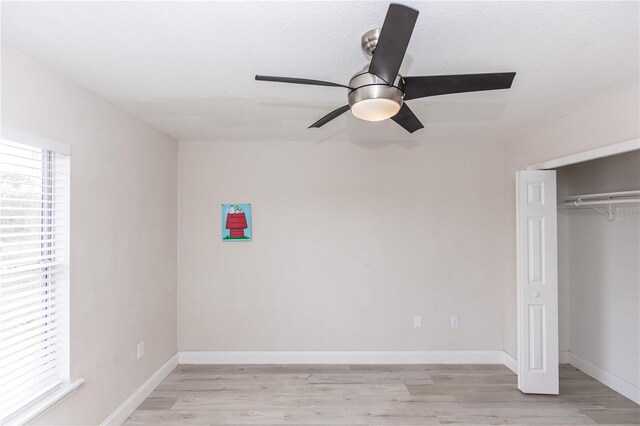 unfurnished bedroom featuring a closet, ceiling fan, and light wood-type flooring