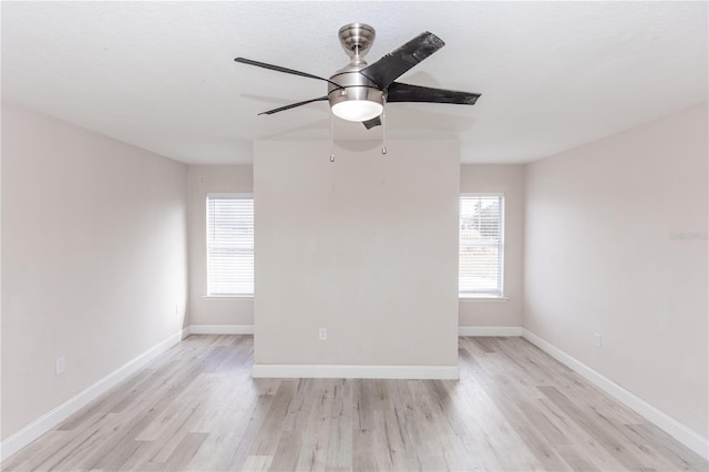 empty room with ceiling fan, a healthy amount of sunlight, and light wood-type flooring