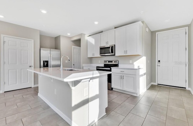 kitchen featuring an island with sink, white cabinetry, sink, a kitchen bar, and stainless steel appliances