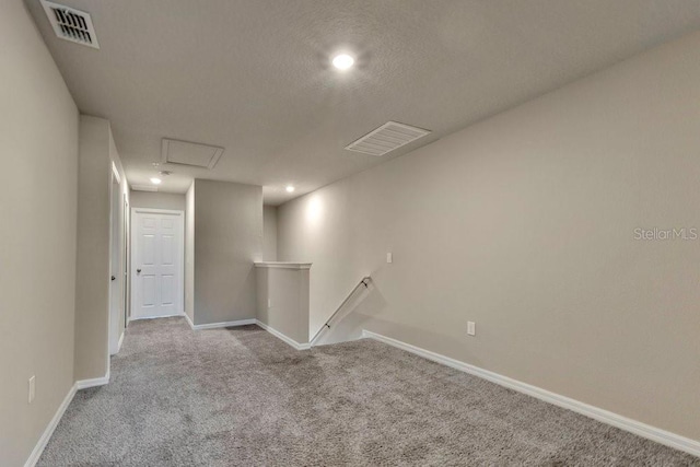 basement with light carpet and a textured ceiling