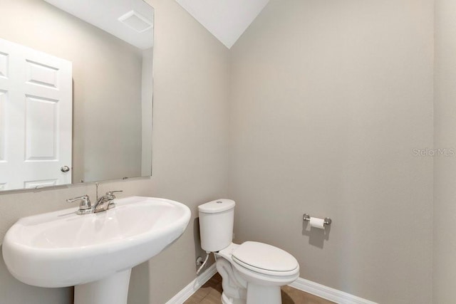 bathroom featuring lofted ceiling, sink, and toilet