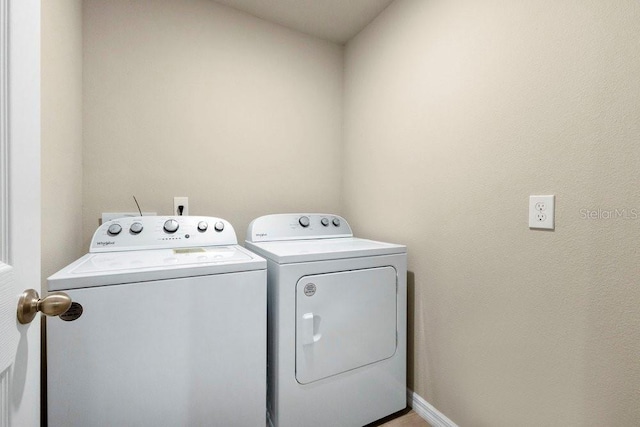 clothes washing area with washer and clothes dryer