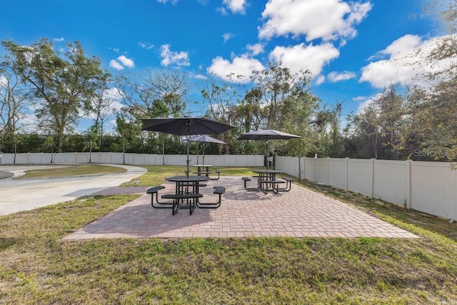 view of home's community featuring a patio area and a lawn