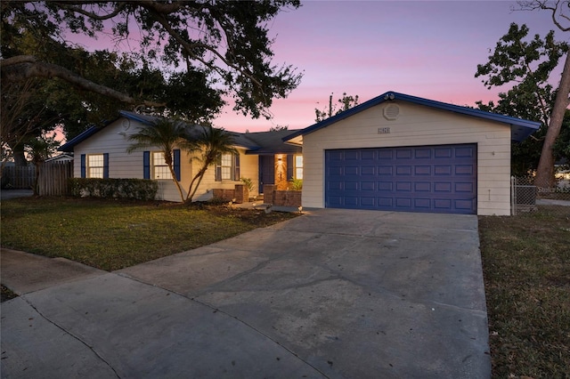 ranch-style house with a garage and a yard