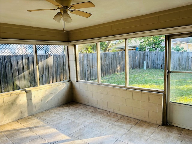 unfurnished sunroom with ceiling fan and a healthy amount of sunlight