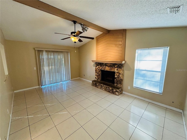 unfurnished living room featuring a stone fireplace, vaulted ceiling with beams, a textured ceiling, light tile patterned floors, and ceiling fan