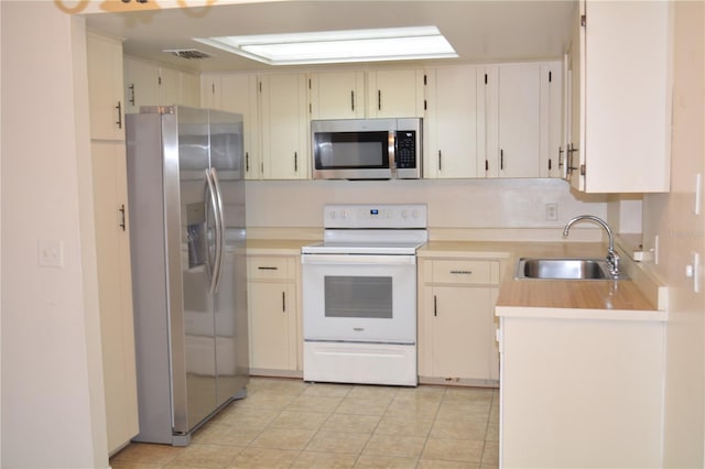 kitchen featuring light tile patterned flooring, appliances with stainless steel finishes, and sink