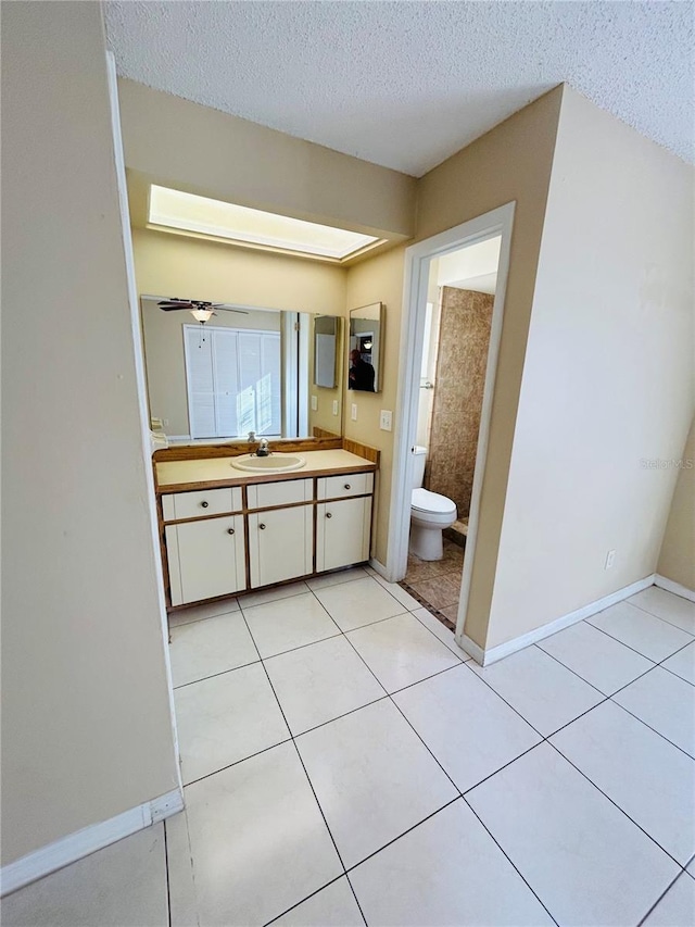 bathroom featuring tile patterned floors, a textured ceiling, and toilet