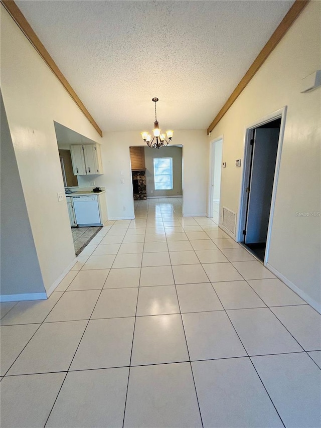 kitchen featuring light tile patterned flooring, vaulted ceiling, a textured ceiling, and a notable chandelier