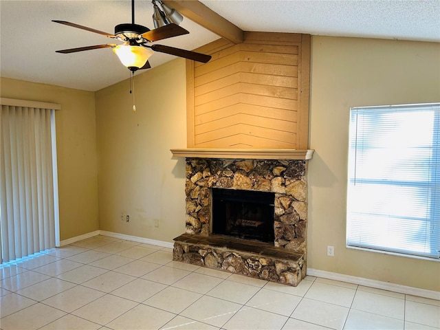 unfurnished living room with light tile patterned flooring, a stone fireplace, vaulted ceiling with beams, ceiling fan, and a textured ceiling