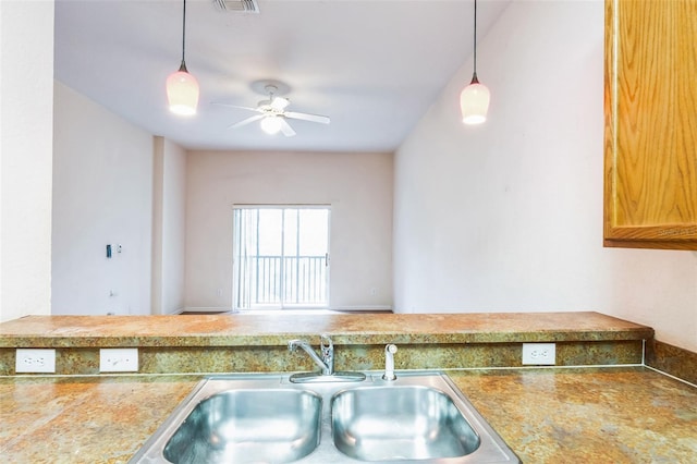 kitchen with sink, decorative light fixtures, and ceiling fan