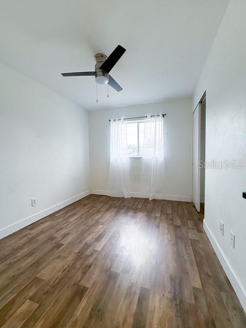 unfurnished room featuring dark hardwood / wood-style floors and ceiling fan