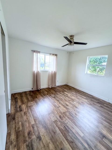 unfurnished bedroom with dark wood-type flooring and ceiling fan