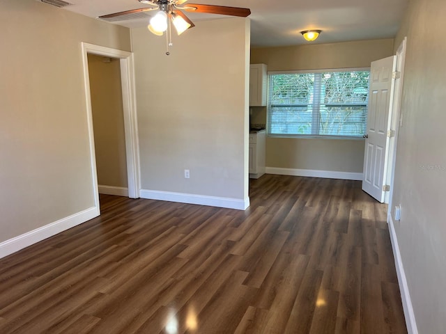 empty room featuring dark hardwood / wood-style flooring and ceiling fan