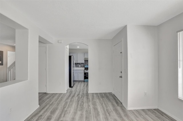 corridor featuring a textured ceiling and light wood-type flooring