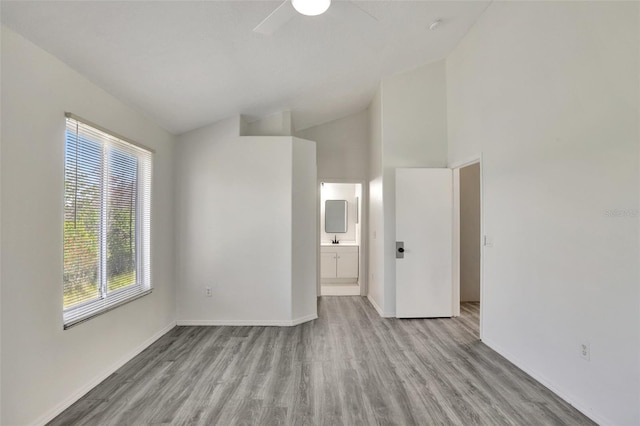 spare room featuring ceiling fan, high vaulted ceiling, and light hardwood / wood-style floors