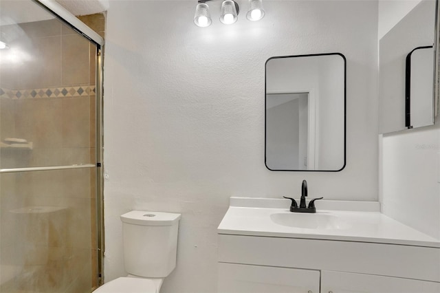 bathroom featuring walk in shower, vanity, and toilet