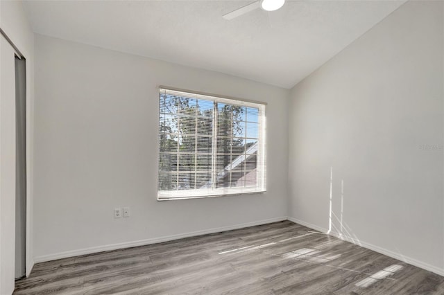 empty room featuring ceiling fan, lofted ceiling, and light wood-type flooring