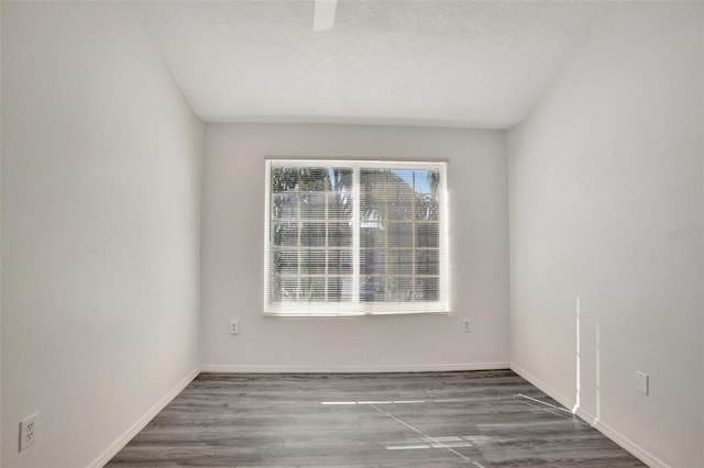 unfurnished room featuring wood-type flooring and a textured ceiling