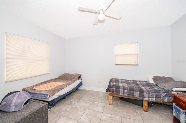 bedroom with light tile patterned floors, a textured ceiling, and ceiling fan