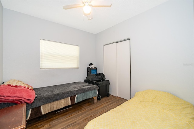 bedroom with dark wood-type flooring, ceiling fan, and a closet