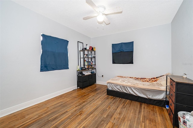 bedroom featuring ceiling fan, wood-type flooring, and a textured ceiling