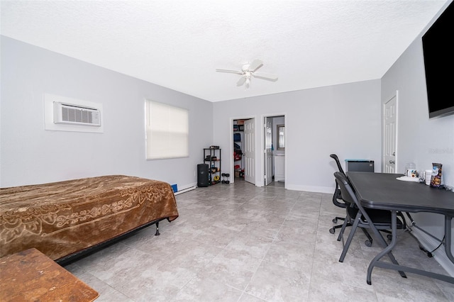 bedroom featuring ceiling fan, a textured ceiling, and an AC wall unit