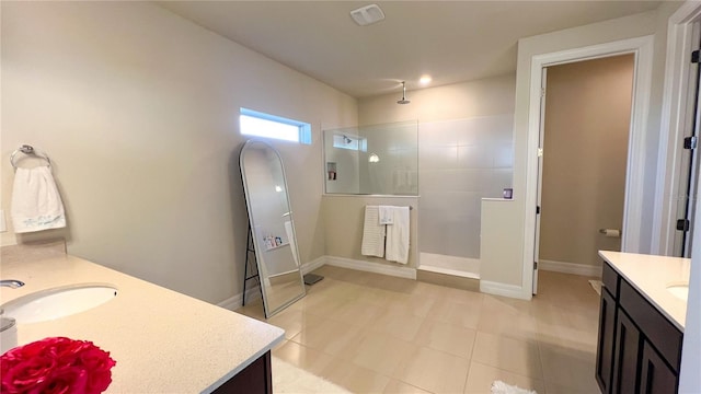 bathroom featuring tiled shower and vanity