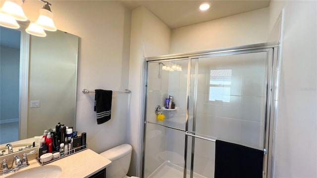 bathroom with an enclosed shower, vanity, and toilet