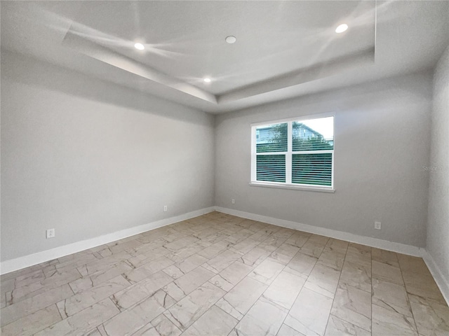 spare room with a tray ceiling